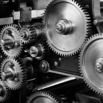 closeup view of gear cogs of a machine – image tries to explains the cost & loan availability to become and Engineer