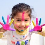 Small girl child with colours -relates to Financial Planning for Children from Young Age: Childs Investments & Savings