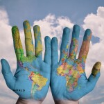 Both hands painted with a world map - relates to $315 Trillion Debt? Global Debt Crisis? Breaking Down the $315 Trillion