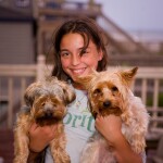 Girl holding two pet dogs